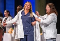 Nursing student receives her white coat at the annual White Coat Ceremony
