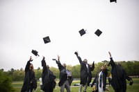 students throwing graduation caps in air