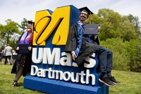 Students pictured on UMass Dartmouth's logo after Commencement.