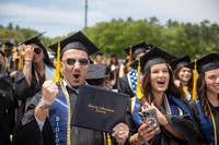 Students pictured with their diploma covers after crossing the stage at Commencement.