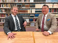 Two male students sitting at library desk