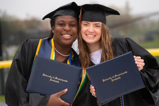 Students smile with diplomas