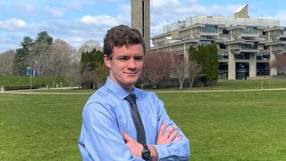 Maxwell White '23, standing in front of the campus quad