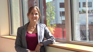 kristina monteiro leaning against a windowsill