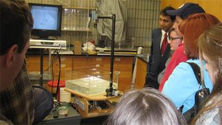 Students watching one of Amit Tandon's demonstrations using the rotating fluids table.