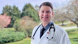 Standing on lawn in lab coat with stethoscope
