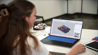 Addie Page working on laptop in studio