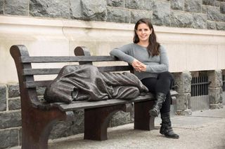 Isabel Saavedra with a sculpture of a homeless person in front of Catholic Charities in Washington, DC.