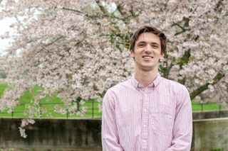 Sean Tocci standing in front of blooming tree