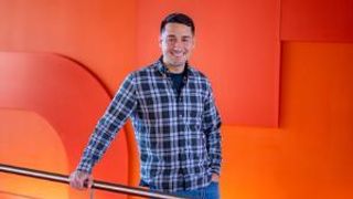 student logan cabral against red wall backdrop