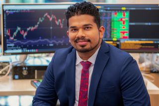 Jeevan Araveti pictured in front of a Bloomberg Terminal in the Charlton Technology Center