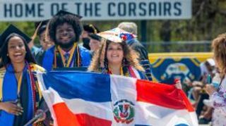 Adriana Lebreault carries a Dominican Republic flag at commencement