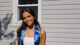Andrea Pires '23 poses in her cord and stole following her commencement
