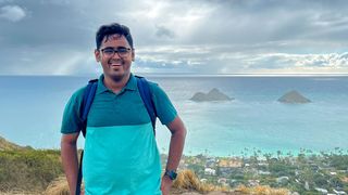 SMAST PhD student Siddhant Kerhalkar standing in front of the ocean