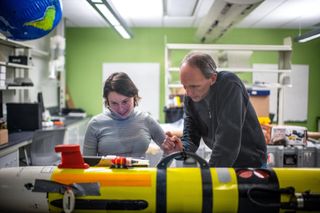 PhD student Agata Piffer Braga and Professor Dan MacDonald at SMAST looking at the autonomous underwater vehicle T-REMUS
