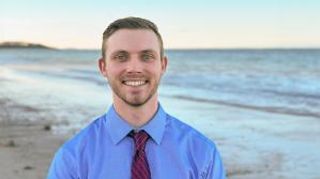 Seth Shea standing in front of the ocean