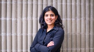 Adwita Saxena smiling, standing with her arms crossed