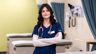 Aubrey Fazzone '26 standing in the nursing simulation lab wearing scrubs