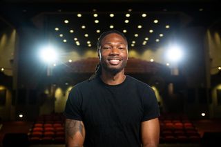 Sam Riley pictured seated in the campus auditorium.