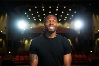 Sam Riley pictured seated in the campus auditorium.