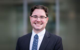 Marshall MacDonald smiling, wearing a suit