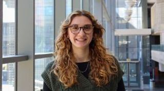 Olivia DeSimone '25 in the library, smiling