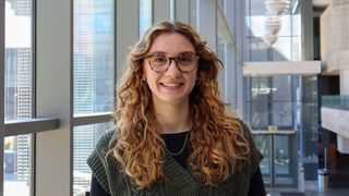 Olivia DeSimone '25 in the library, smiling