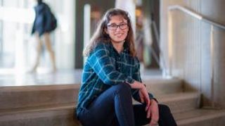 Student sitting on steps in Library