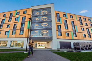 Student walking from Balsam Hall.