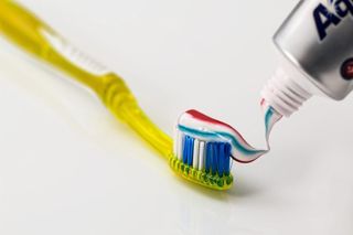 Toothbrush with toothbrush being squeezed onto bristles
