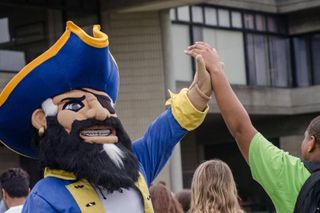 Arnie the Corsair gives a high five to a student