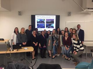 Design students posing in front of slideshow