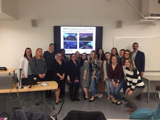 Design students posing in front of slideshow