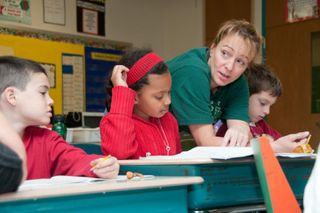 Teacher helping elementary students