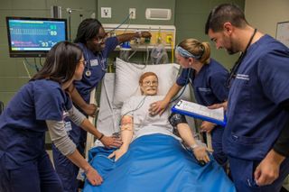 Nursing students attend to a patient in the Sim Lab