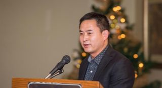 Honggang Wang speaking at lecturn