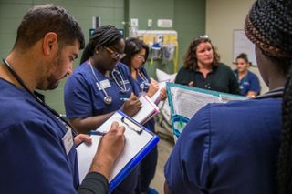 UMass Dartmouth Nursing students in simulation lab taking notes
