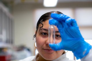 Student in Mark Altabet's lab examining a glass vial
