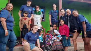 UMassD students pose with local Guatemalans during their alternative spring break