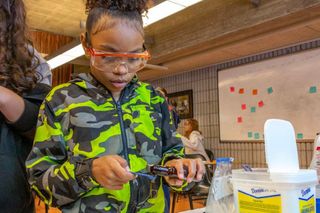 Yaribel Matos measures out vanilla to flavor the homemade ice cream the students would make using their newly-acquired knowledge of thermodynamics. Photo courtesy: Morgan Beard, Dartmouth Week