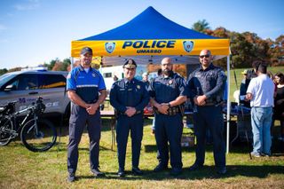 Police officers standing in front of tent at blue and gold weekend