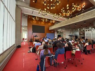audience watching a speaker present research