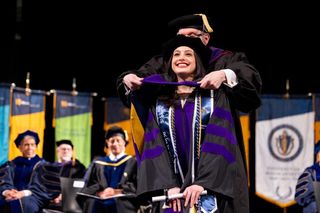 Paulina Aguilar Delgado receives her hood from Prof. Philip Cleary.