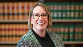 Female student standing in front of law books