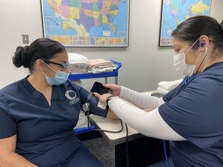 CNA Students practicing taking each other's blood pressure