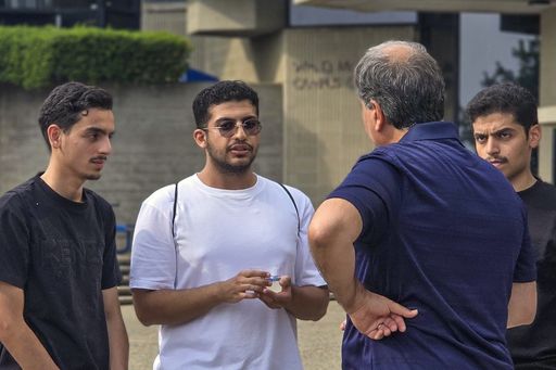 Saudi students speaking with faculty, on the quad