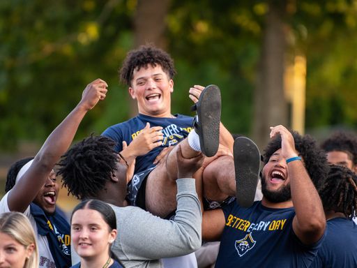 A football player lifted on the shoulders of his teammates