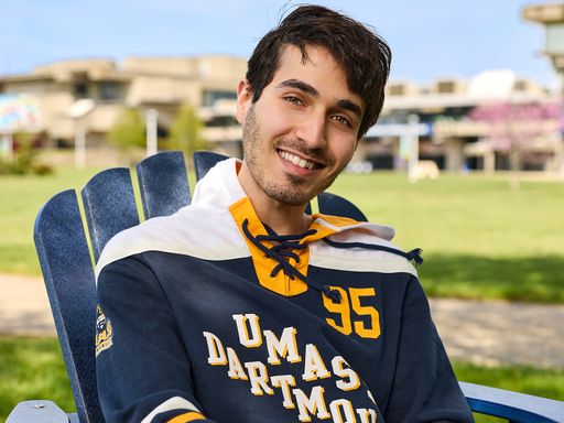 Male student in Adirondack chair on the quad