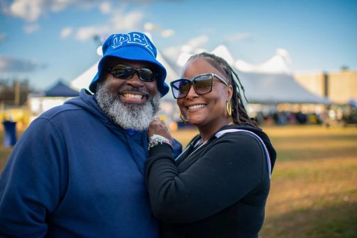 A smiling couple poses for a photo at the Blue & Gold Family Festival