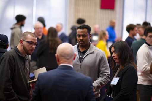 Students and alumni speaking in a group at networking event